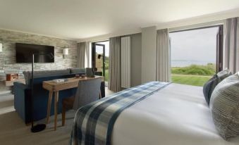 a bedroom with a large bed and a view of the outdoors through a window at Isle of Mull Hotel and Spa