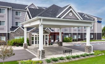 a large white building with a covered entrance and a paved walkway leading to it at Microtel Inn & Suites by Wyndham Warsaw