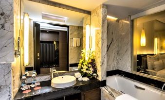 a luxurious bathroom with a large bathtub surrounded by marble , creating a warm and inviting atmosphere at Le Méridien Coimbatore