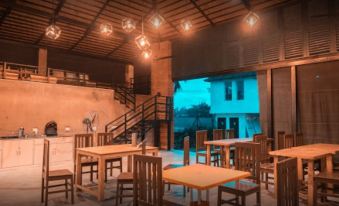 an outdoor dining area with wooden tables and chairs , providing a pleasant atmosphere for guests at Mayas
