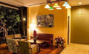 a cozy living room with yellow walls , a leather couch , and a painting on the wall at Aroonsawad Riverview Resort