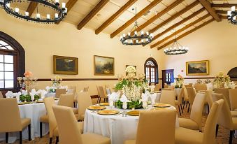 a large dining room with round tables and chairs , set for a formal event or a wedding reception at Hotel Mission de Oro
