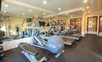 a well - equipped gym with various exercise equipment , including treadmills and weight machines , set up in a spacious room at Best Western Plus Carpinteria Inn