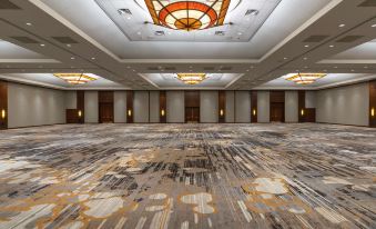 a large , empty ballroom with a carpeted floor and a chandelier hanging from the ceiling at Hyatt Regency Coralville Hotel & Conference Center