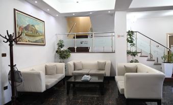 a modern office space with white walls , black floor , and several couches arranged around a coffee table at Hotel Liss