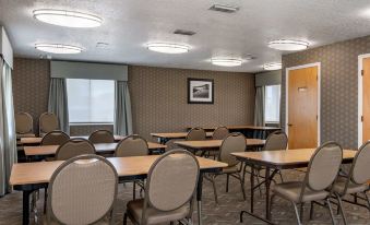 a conference room with tables and chairs , a painting on the wall , and large windows at Best Western Space Shuttle Inn