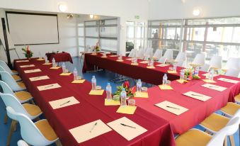 a conference room set up for a meeting , with multiple tables and chairs arranged in a semicircle at Hotel Saint - Georges