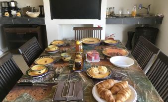 a dining table is set with a variety of food items , including croissants and other pastries at Country Comfort