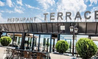 "a modern building with a large sign that reads "" restaurant terra "" prominently displayed on the front" at Garden Palace