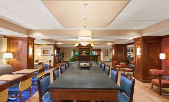 a large conference room with a long wooden table and blue chairs , set up for a meeting at Hampton Inn Warrenton, VA