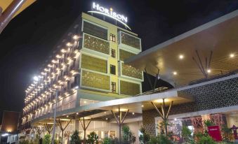 "a large hotel building lit up at night , with the name "" horizon "" prominently displayed on the front" at Hotel Horison Gkb Gresik