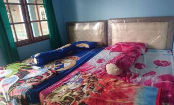 a bed with two pillows , one of which has a star symbol on it , and the other is made of blue material at Penginapan Rindu Alam Soala Gogo