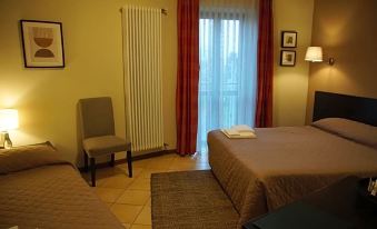 a room with two beds , one on the left side and the other on the right side of the room at Hotel Del Corso