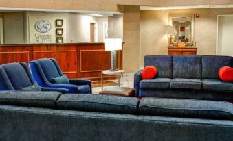 "a hotel lobby with a couch , chairs , and a dining table , along with the reception desk and a sign reading "" wheelchair lift "" on" at Comfort Suites Gadsden Attalla