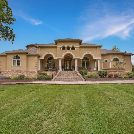 Stunning waterfront villa with indoor pool and kids swing set and play area.