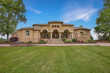 Stunning waterfront villa with indoor pool and kids swing set and play area.