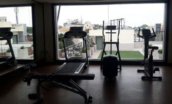 a well - equipped gym with various exercise equipment , including a treadmill , weights , and a punching bag at Hotel La