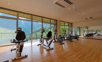 a gym with a variety of exercise equipment , including treadmills , stationary bikes , and weight machines at Okuhita Onsen Umehibiki