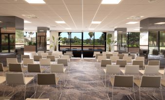 a conference room with rows of chairs arranged in a semicircle , and a podium at the front of the room at DoubleTree by Hilton Islantilla Beach Golf Resort