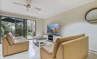 a living room with a large flat - screen tv mounted on the wall , a couch , and a dining table at North Pier Hotel