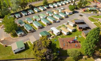 aerial view of a campground with multiple rvs parked in a lot , surrounded by trees and grass at Discovery Parks - Hadspen