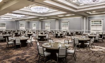 a large dining room with multiple tables and chairs arranged for a formal event , possibly a wedding reception at Hyatt Regency Long Island