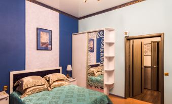 a bedroom with blue walls , a white ceiling fan , and a bed with blue bedding at Diana Hotel