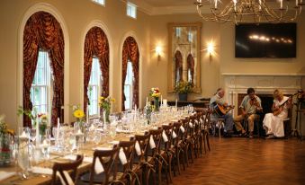a long dining table set up for a formal event , with several chairs arranged around it at Peter Allen Inn & Event Center