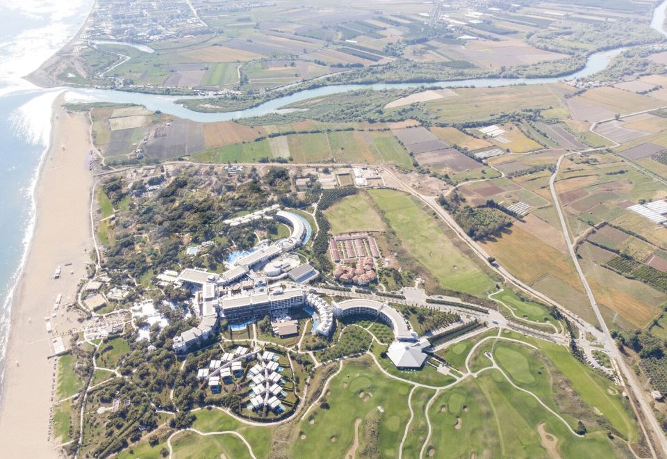 aerial view of a modern city surrounded by green fields , with a river flowing nearby at Lykia World Antalya
