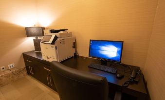 a computer desk with a monitor , keyboard , and printer , along with a chair and lamp at Soboba Casino Resort