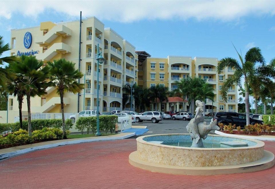 a residential area with a fountain in the middle of a park - like area , surrounded by buildings and cars at Aquarius Vacation Club at Boqueron Beach Resort