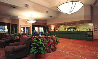a hotel lobby with a reception desk and a large , illuminated sign above it at Shilo Inn Suites Klamath Falls
