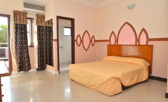 a large bed with a wooden headboard is in a room with pink and brown walls at Hotel International