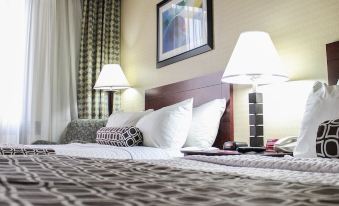 a hotel room with a large bed , two lamps on either side of the bed , and a television at Crowne Plaza Cleveland Airport