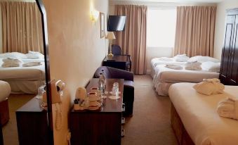 a hotel room with three beds , two of which are twin beds and one is a double bed at Skylark Hotel