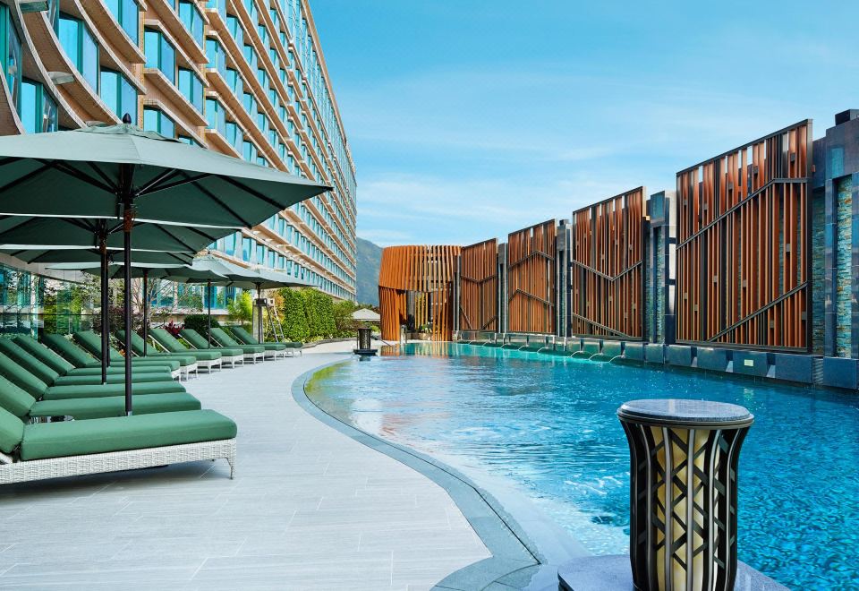 There is a swimming pool surrounded by buildings and the sky in the background, along with other nearby hotels at Royal Plaza Hotel