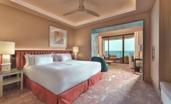 a large bed with a red headboard is in a room with a sliding glass door leading to a balcony at El Fuerte Marbella