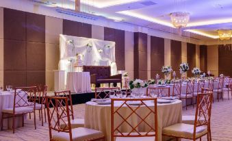 a large dining room with multiple tables and chairs , some of which are set up for a wedding reception at Summit Hotel Tacloban