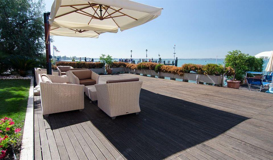 a rooftop patio with several chairs and an umbrella , providing a relaxing atmosphere overlooking the ocean at Hotel Eden