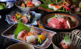 a dining table with a variety of dishes , including sushi , meat , and other food items at Yufuin Bath Satoyamasafu