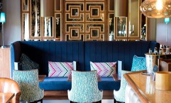 a well - decorated living room with various pieces of furniture , including couches , chairs , and a dining table at Thornton Hall Hotel & Spa