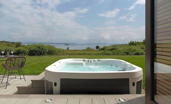 a large hot tub with a view of the ocean and grassy area in the background at Isle of Mull Hotel and Spa