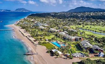 aerial view of a beautiful beach resort with multiple buildings , palm trees , and a golf course at Four Seasons Resort Nevis