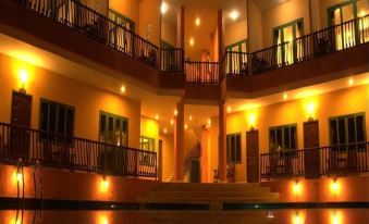 a beautiful hotel with multiple floors , each having balconies and lit by lights at night at Samprasob Resort