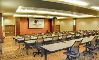 a conference room with rows of tables and chairs , a screen displaying the dare to dream logo at DoubleTree by Hilton Reading