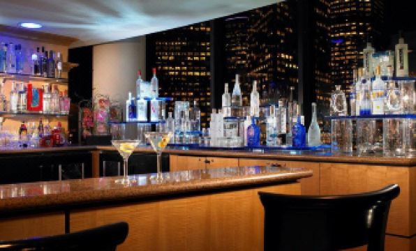 a well - stocked bar with various bottles of liquor , wine glasses , and bottles of alcohol on the counter at The Westin Bonaventure Hotel & Suites, Los Angeles