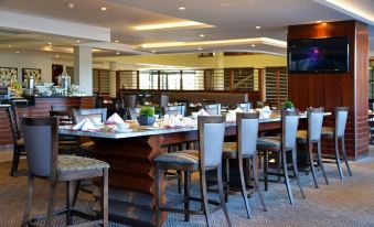 a large dining room with a long wooden table and multiple chairs , creating an elegant atmosphere at Indaba Lodge Gaborone