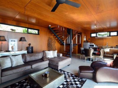a modern living room with wooden ceiling , large windows , and black and white checkered rug at Spicers Sangoma Retreat