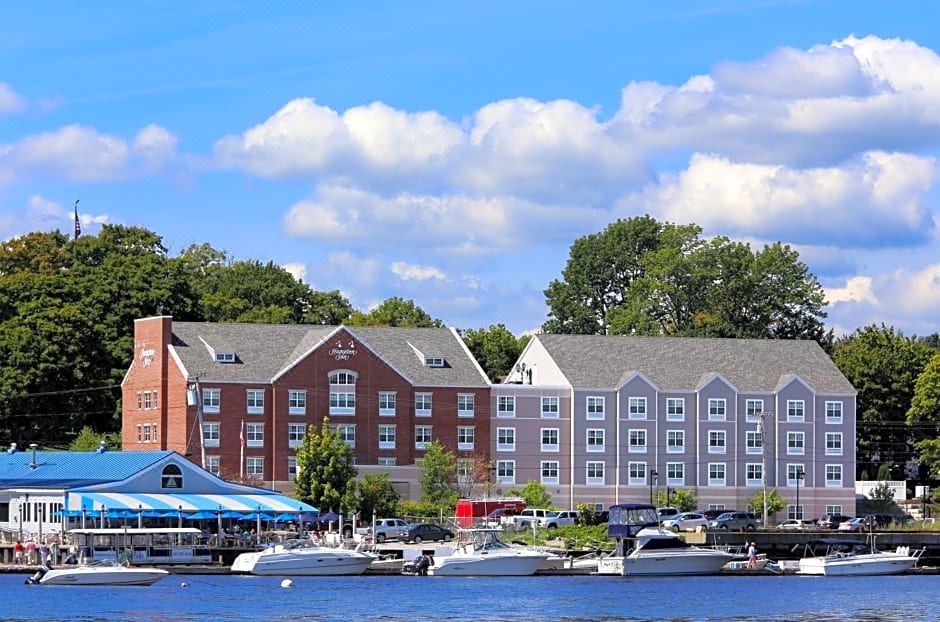 a boat dock near a hotel with multiple boats and a marina in the background at Hampton Inn Bath (Brunswick Area)