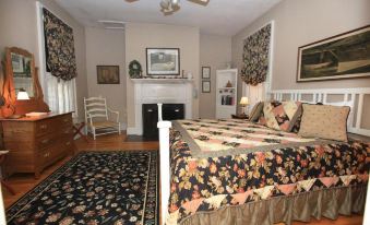 a cozy bedroom with a large bed , a fireplace , and a rug on the floor at Lafayette Inn